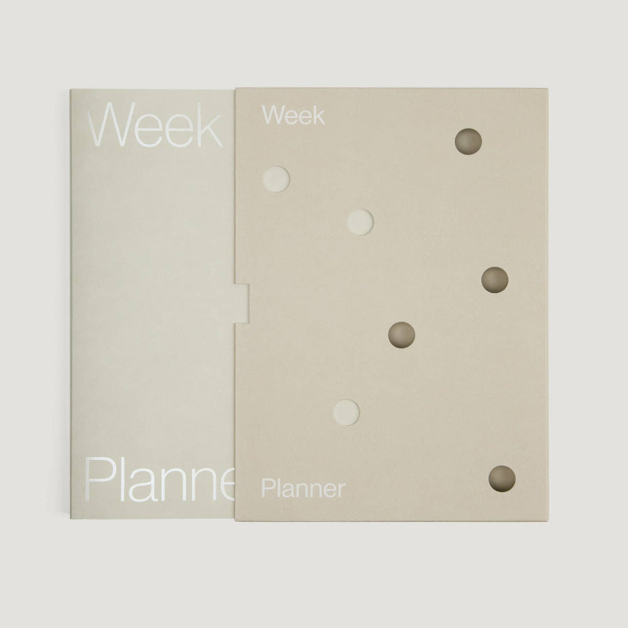 Two beige planner pages with 'Week' text and circular holes on a white background