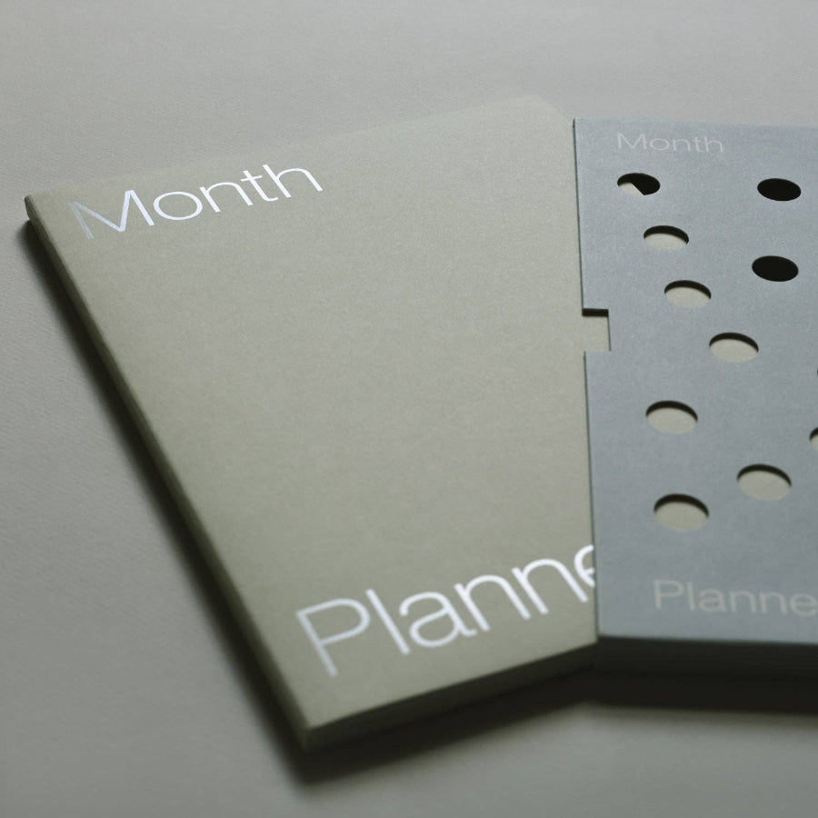 Two beige planners with 'Month' and 'Planner' text on a light gray background