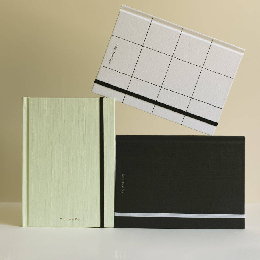 Three notebooks with different covers on a beige background
