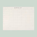 White monthly list planner on a light gray background
