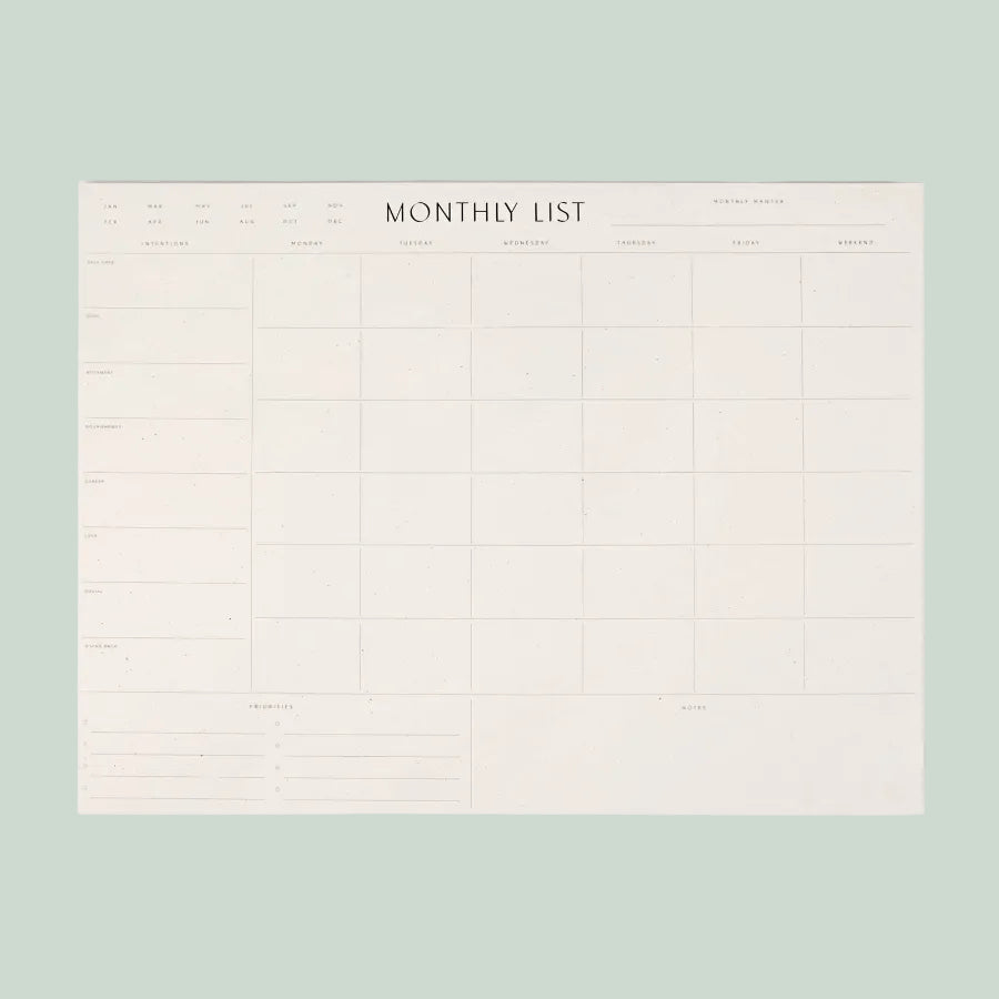 White monthly list planner on a light gray background