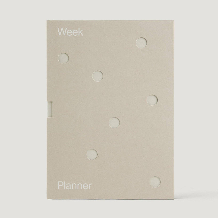 Beige planner with 'Week' and 'Planner' text on a white background