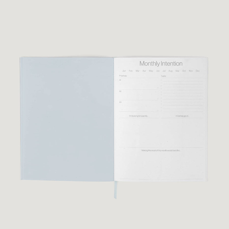 Two sheets of paper with a light blue cover and white text area on a beige background