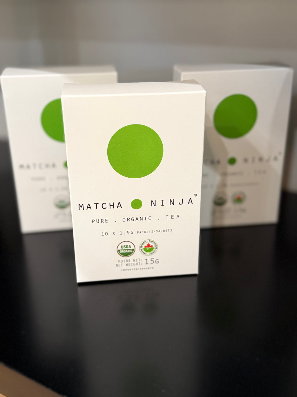 Matcha Ninja tea boxes on a black surface with a blurred background