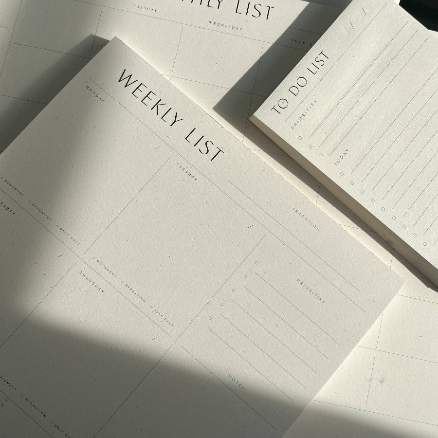Planners with monthly, weekly, and to-do list sections on a light surface.