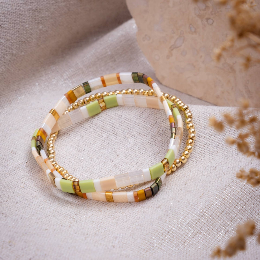 Stack of beaded bracelets on a textured surface