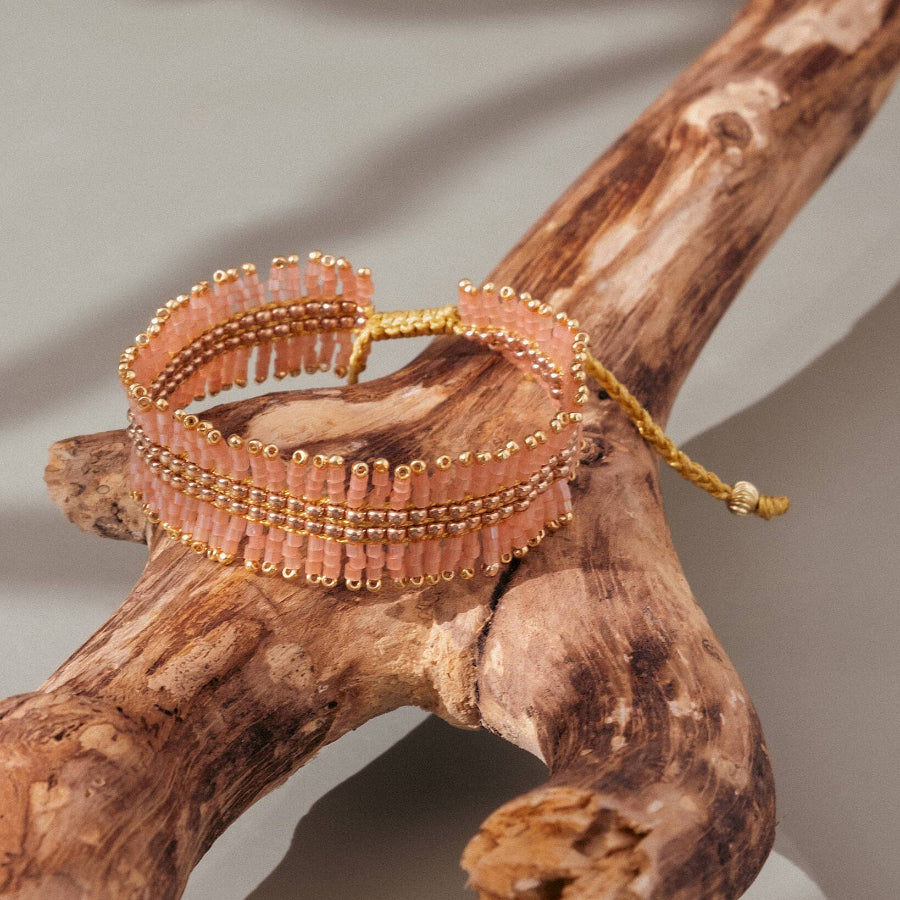Beaded bracelet on a piece of wood with a neutral background